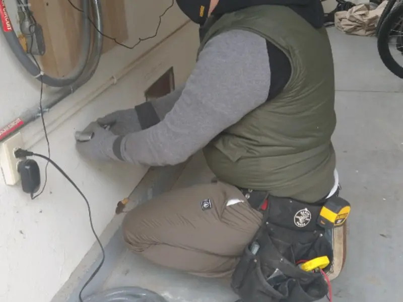 Electrician performing outlet wiring in a Sweden garage